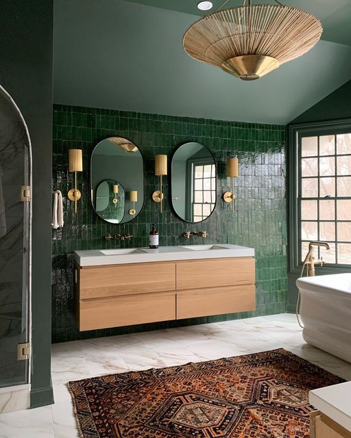A green bathroom with wooden vanity and white counter top and white floor
