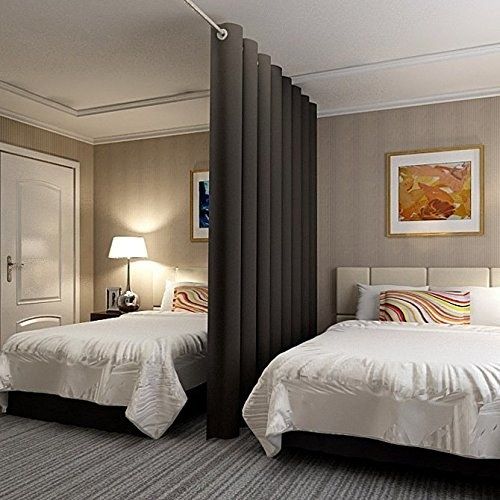 A bedroom with two beds and curtains and lamp on the side table 