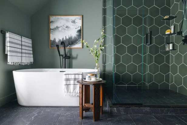 A green bathroom with dark green wall and white bathtub and black floor