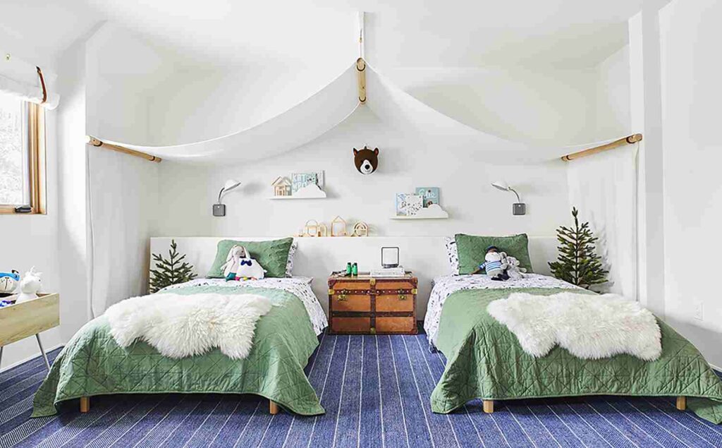 A two bed and wall canopies and lights on the wall and wooden deck