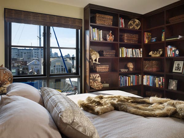 A white bedroom with book shelves and window