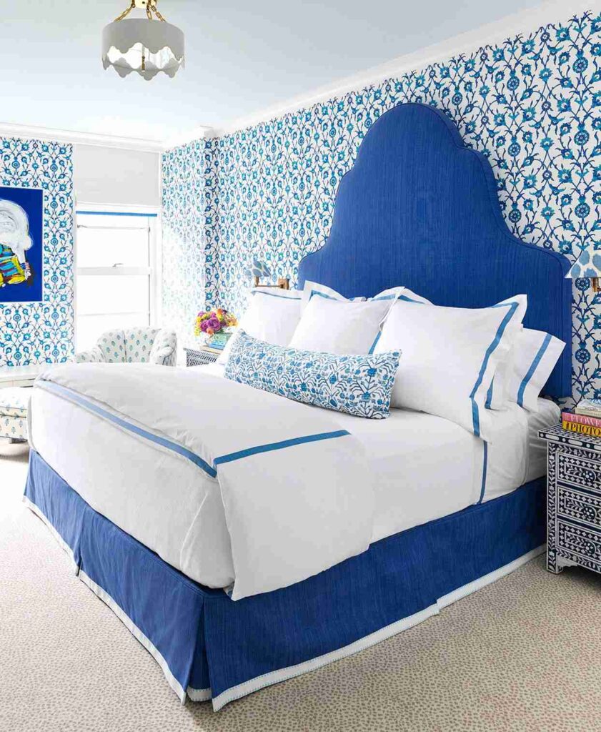 A white and blue bedroom with blue bedding and white blankets and pillow