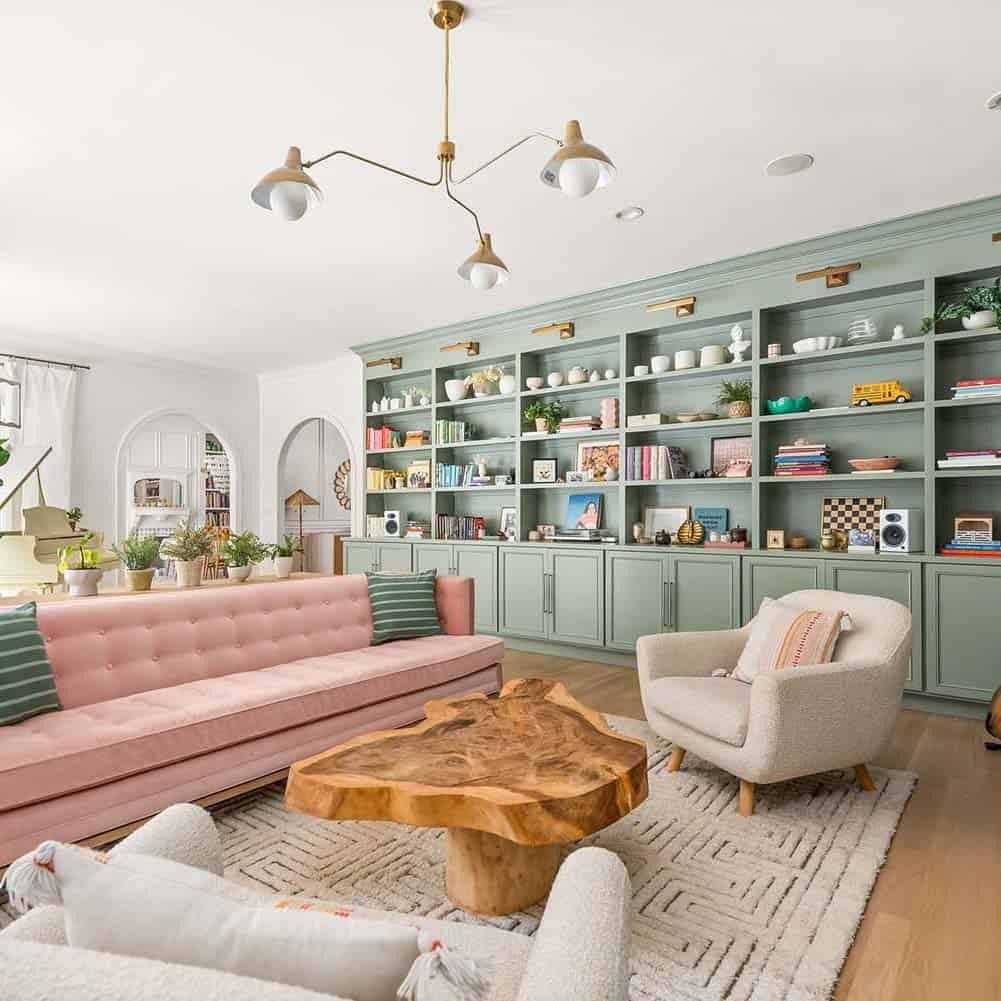 A white living room with Sage built-ins and pink sofa with cushion 